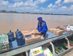 PERSONEL SATPOLAIRUD POLRES KAPUAS BANTU MASYARAKAT MENGANGKAT BARANG DI DERMAGA PELABUHAN